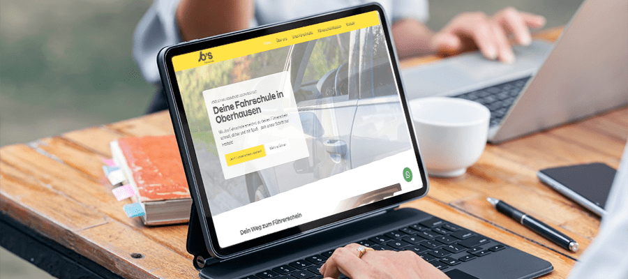 Website einer Fahrschule in Oberhausen mit gelber Akzentfarbe auf einem Tablet mit Tastatur