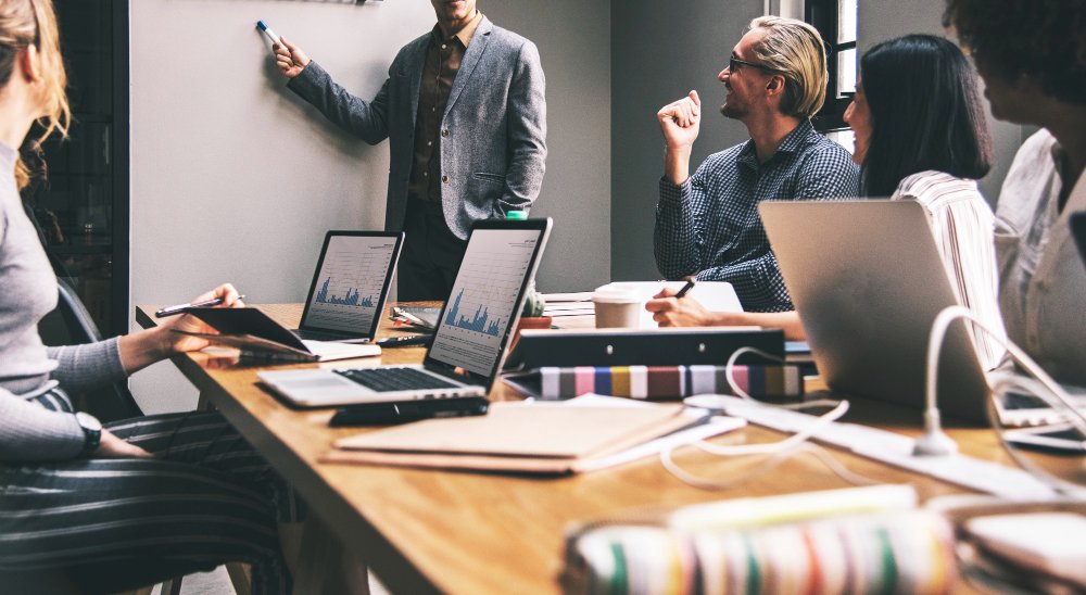 Redaktionsteam plant und bespricht die Inhalte eines Online-Magazins an einem Konferenztisch.